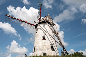 Obraz premium Traditional windmill on a hill in Bruges under blue sky