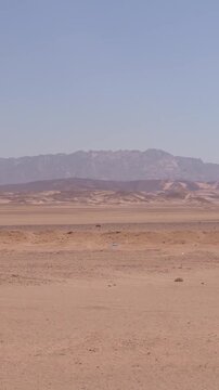 Expansive desert landscape with distant mountain range under clear sky Egypt. Hurghada