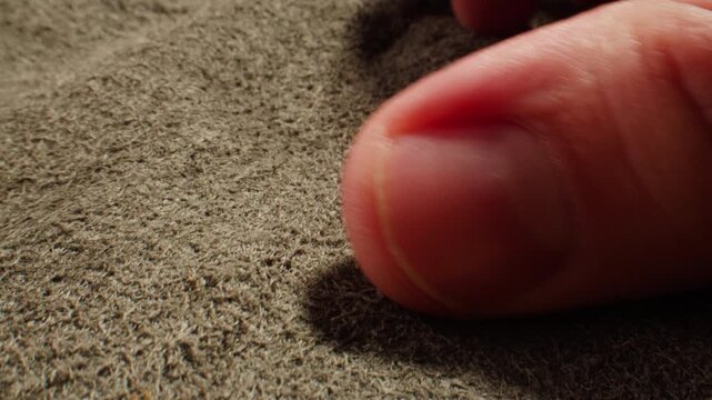 Nubuck touched by finger, hand feeling grey suede leather texture extreme close up macro, leather goods quality for shoes and clothing production