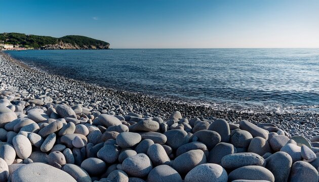 smooth gray pebbles covering rocky beach surface with natural stone texture and coastal background