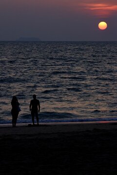 Silhouettes de deux personnes face &agrave; un coucher de soleil sur la mer