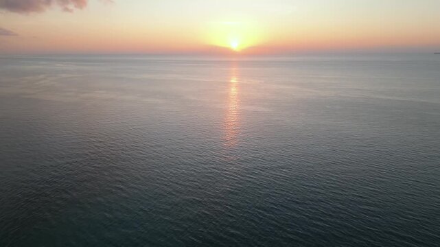 Golden sunrise glow spreading softly across calm miami waters