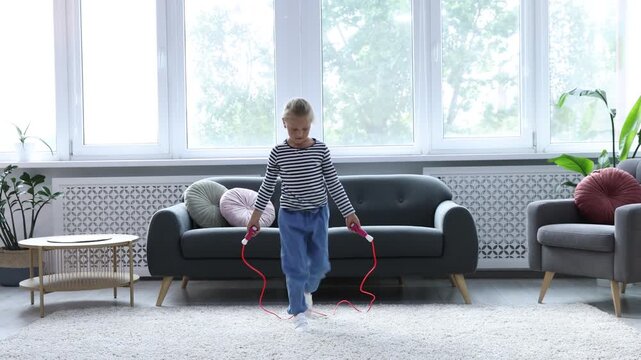 Cute little girl jumping with skipping rope at home