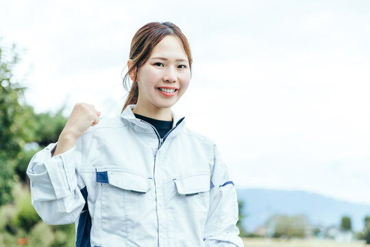 作業着でガッツポーズする女性
Female Worker in Workwear Making a Fist Pump