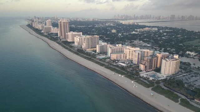 Drone flight tracing the hazy shoreline of miami beach at dusk