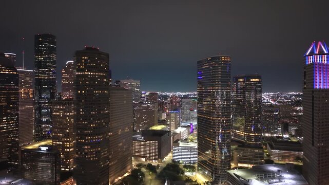 Houston, Texas at night with modern high-rise buildings and multi-lane highways. Bustling downtown district reflects economic strength.
