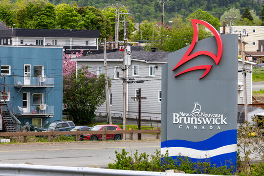 Gaspesie, Quebec, 06 June 2026 : A large sign displays the New Brunswick Canada logo and name in a residential area.