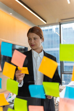 Business, people, idea, startup and education concept Sticky note on glass wall.