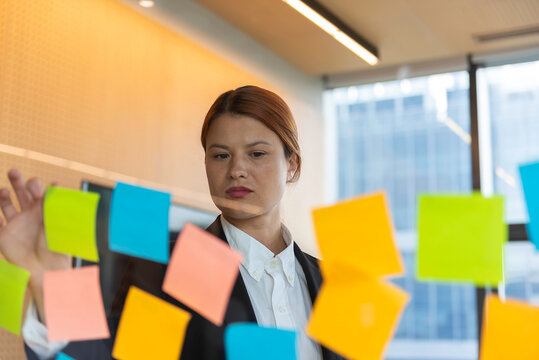 Business, people, idea, startup and education concept Sticky note on glass wall.