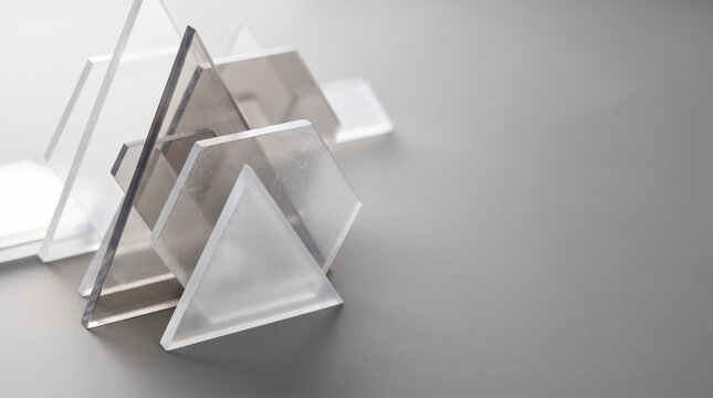 Abstract geometric glass and acrylic shapes composition on soft gray background