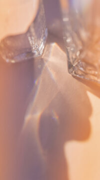 Abstract light refraction and prism effect with glass crystal shadows on a warm pastel peach background
