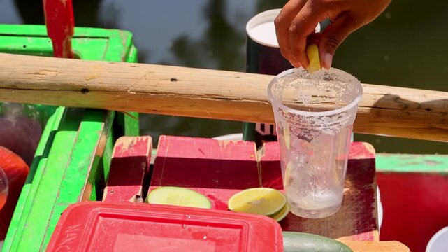 Hand Squeezing Lime Into Plastic Cup Aboard Xochimilco Trajinera Mexico City