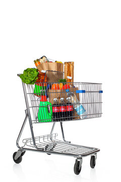 Full Shopping Cart Filled with Groceries and Produce on white background