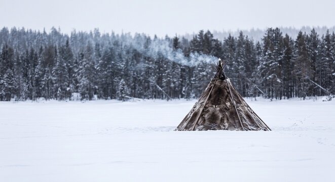 Evenki reindeer-hide chum tent standing alone in snowy taiga forest clearing