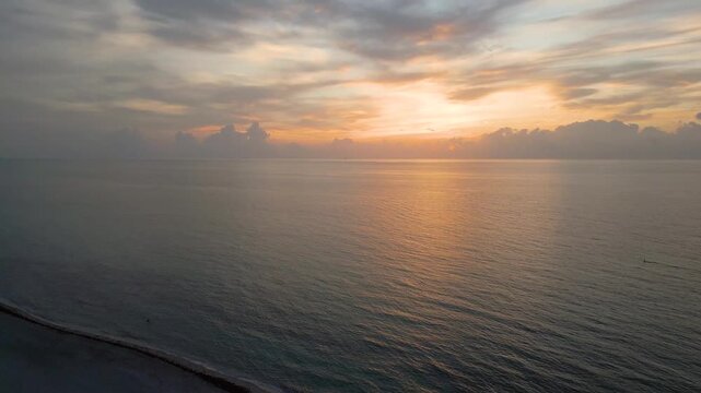 Aerial descent over a quiet miami beach at golden dusk