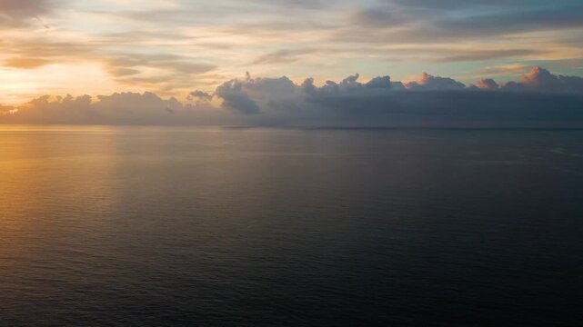 Golden sunrise glow spreading over calm atlantic waters near miami