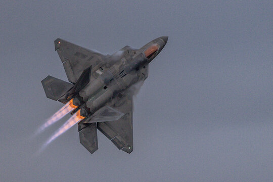 F 22 Raptor powers upward with afterburners lit
