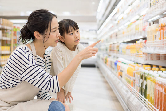 スーパーで商品を選ぶ母親と娘