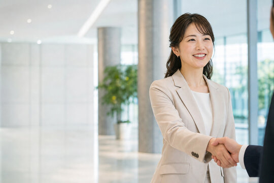 オフィスで握手する笑顔の女性会社員