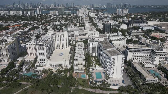 Aerial drift along miami beach hotels bordering a sunlit sandy shoreline