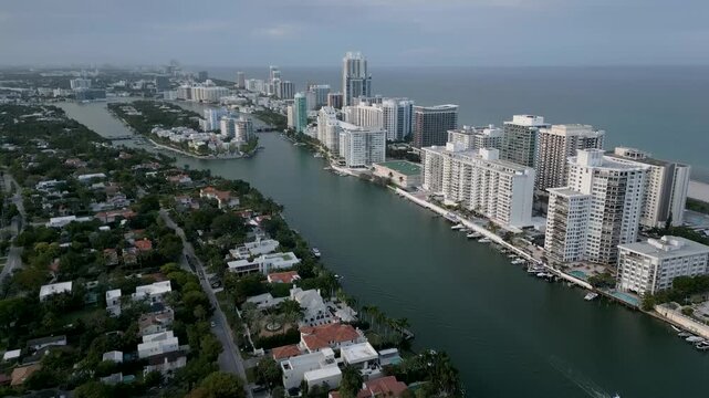 Aerial sweep over a miami beach waterway lined with residential towers