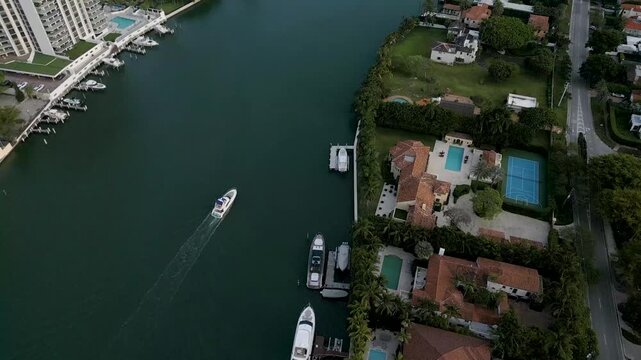 Aerial trace of a boat gliding past luxury waterfront estates in miami beach