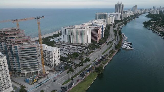 Aerial glide past a waterfront construction crane and miami beach towers