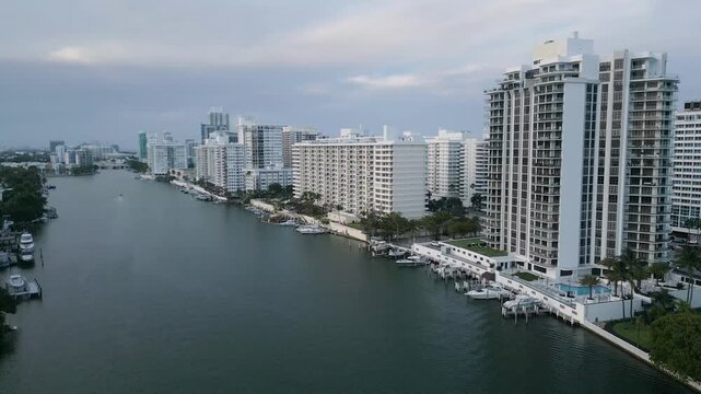 Aerial approach toward a cluster of miami beach high rises along a calm waterway