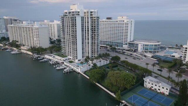 Aerial flyover of miami beach towers between a coastal waterway and the ocean