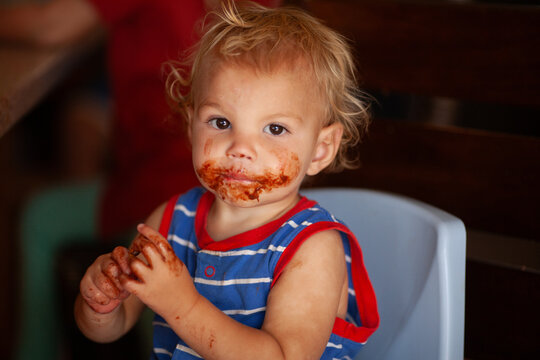 Messy Toddler With Food Covered Face During Mealtime
