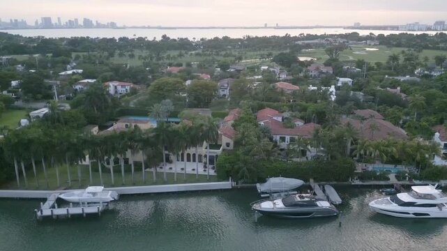 Aerial flyover of lavish waterfront estates lining a miami beach canal