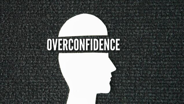 Human head shape with the word Overconfidence. cognitive bias where a person's subjective confidence in their knowledge, judgment, or abilities is greater than their objective accuracy