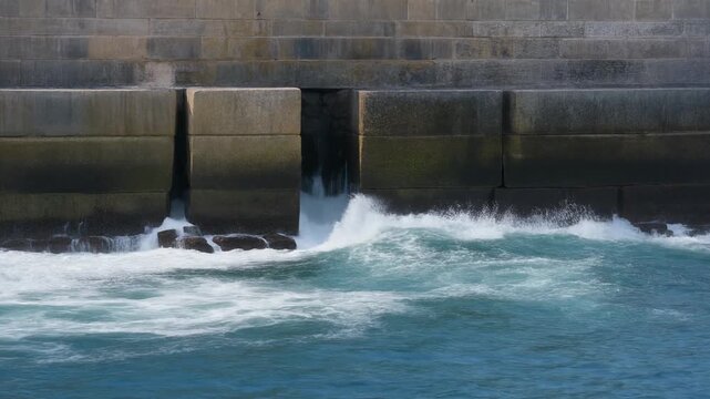 Foam draining through a sea wall