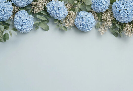 Elegant blue hydrangea and baby's breath floral top border with eucalyptus on light blue background with copy space for wedding invitations