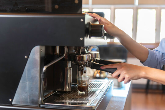 Coffee grinder grinds fresh coffee beans into a portafilter for espresso machine. Barista grind coffee bean with grinder machine.