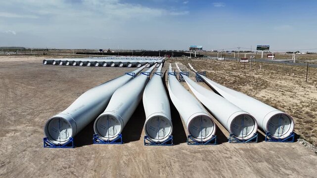 white wind turbine blades stacked outdoors for renewable energy production