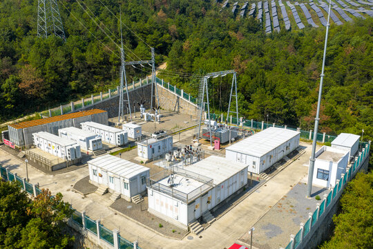Aerial view of mountain photovoltaic power station with associated substation facilities and transmission infrastructure
