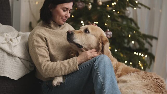 Female Owner At Home Petting Adorable Golden Retriever Dog