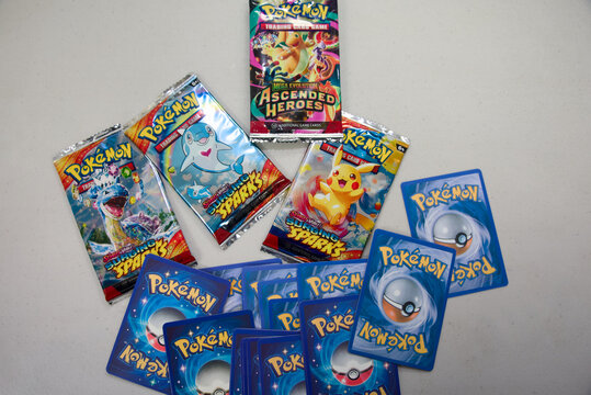 Semaphore, South Australia - July 22 2026: Unofficial fake trading card game booster packs and loose collectible cards on a white surface, representing counterfeit products