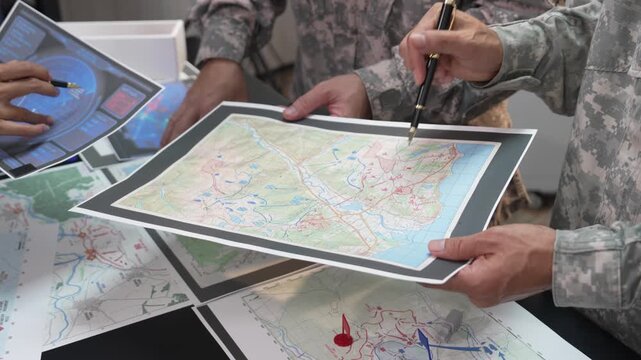 Military Officers Planning Battle Strategy using Tactical Map, Flags and Models on Table