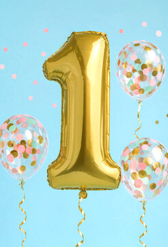 Golden number one balloon with colorful confetti filled balloons