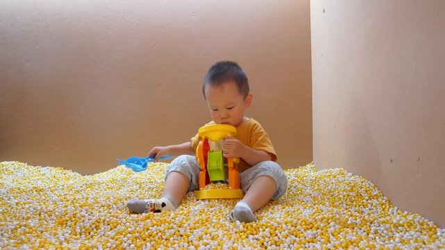 Full-length view of toddler playing with toy excavator in indoor play area