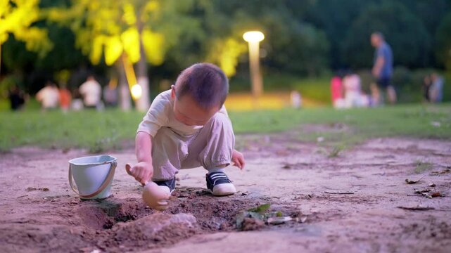 Full-length view of toddler digging hole with bucket outdoors