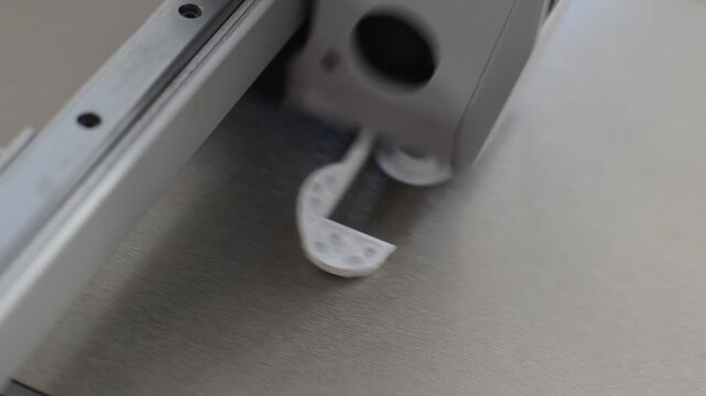 Extreme macro view of a 3D printer nozzle extruding fine plastic layers on print bed