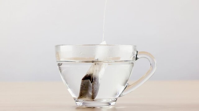 Dipping Tea Bag in Glass Cup with Hot Water Brewing Herbal Tea