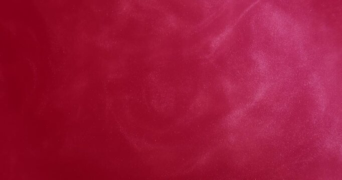 Red ink flow. Glitter splash. Defocused bright pink color spatter water acrylic vivid fluid texture spill on abstract art background.