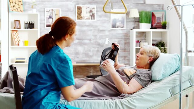 Nurse introducing VR headset to older patient in care facility