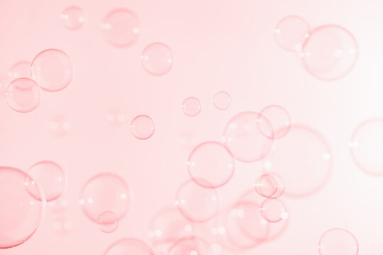 Pink Soap Bubbles Floating in The Air. Celebration Festive Backdrop. Freshness Clear Soap Suds Bubbles Water. Pink and White Gradient Blurred Background.	
