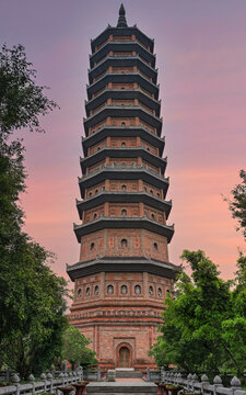 The iconic Bao Thap pagoda at Bai Dinh Temple in Ninh Binh, Vietnam, captured against a vibrant sunset sky