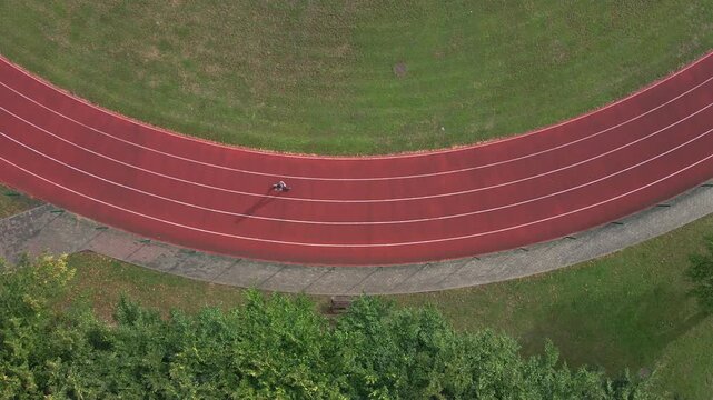 Woman jogging on running track during morning workout, top view
